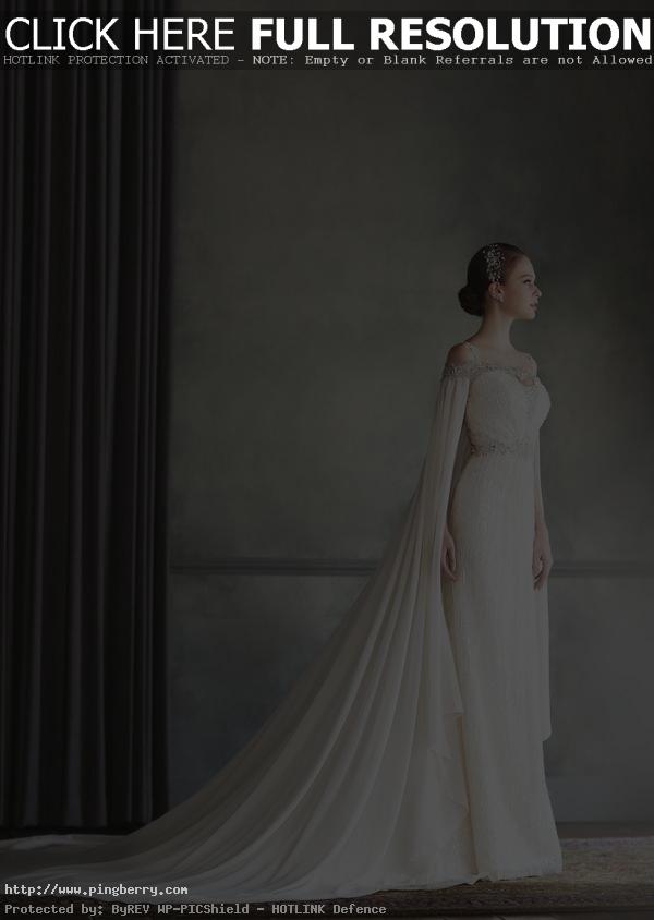 How beautiful is this Bonheur Sposa gown featuring an unique off-the-shoulder jeweled neckline and a stylish cape!